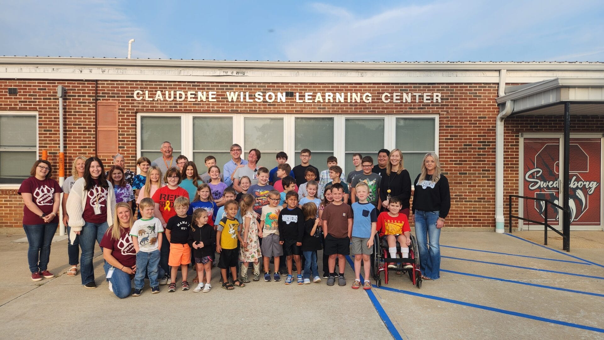 The Swedeborg District III Elementary School building in Missouri has been renamed after its longtime custodian, Claudene Wilson, back row center, who retired in July. (Photo by Swedeborg R-III School District via CNN Newsource)