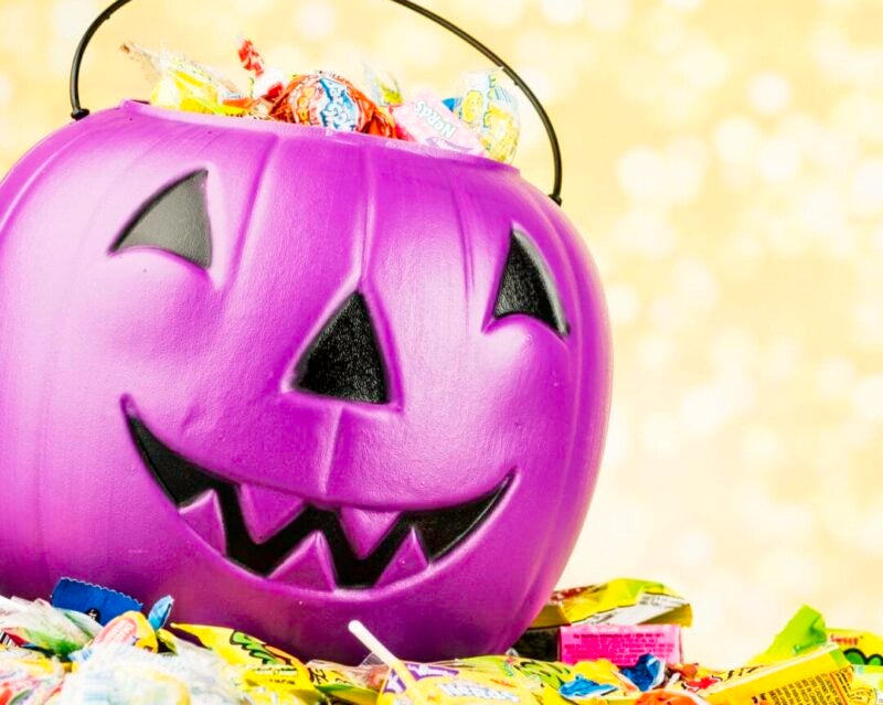 A studio shot of a purple plastic pumpkin head bucket filled with an assortment of small packaged candies that are sold in stores around the country for Halloween. Candystore.com asked customers to name the worst Halloween candies. From Necco Wafers to Peanut Butter Kisses, here's how the worst of the worst stack up. (Photo by CatLane via Getty Images)