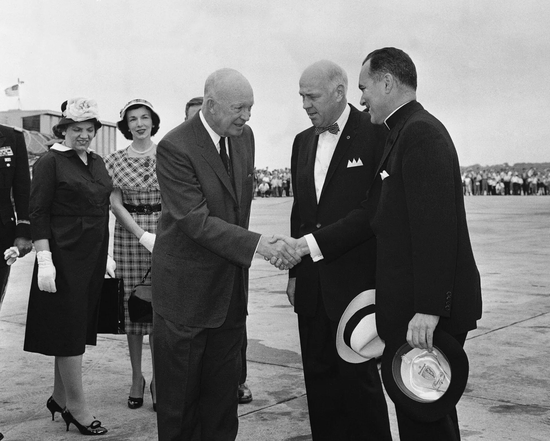 President Dwight Eisenhower is greeted at airport at South Bend, Indiana on June 5, 1960 by Father Theodore Hesburgh C.S.C., right, president of the University of Notre Dame, and Indiana Gov. Harold Handley, center. The president will speak at the Notre Dame commencement. (AP Photo)