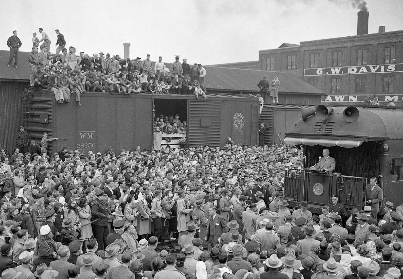 President Harry S. Truman, on a train trip across America, stops in Richmond, Indiana, on Oct. 15, 1948. President Truman is on the platform of the train and a crowd has gathered at the train station to see him. (Photo by Getty Images)