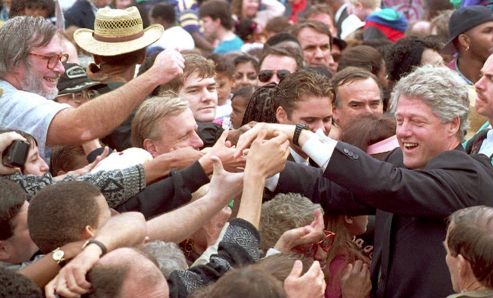 US President Bill Clinton (R) greets the crowd after giving a speech at a groundbreaking ceremony May 14, 1994, for a Martin Luther King Jr. and Robert F. Kennedy statue at the Martin Luther King Jr. Memorial Park in Indianapolis. (Photo by J. DAVID AKE/AFP via Getty Images)