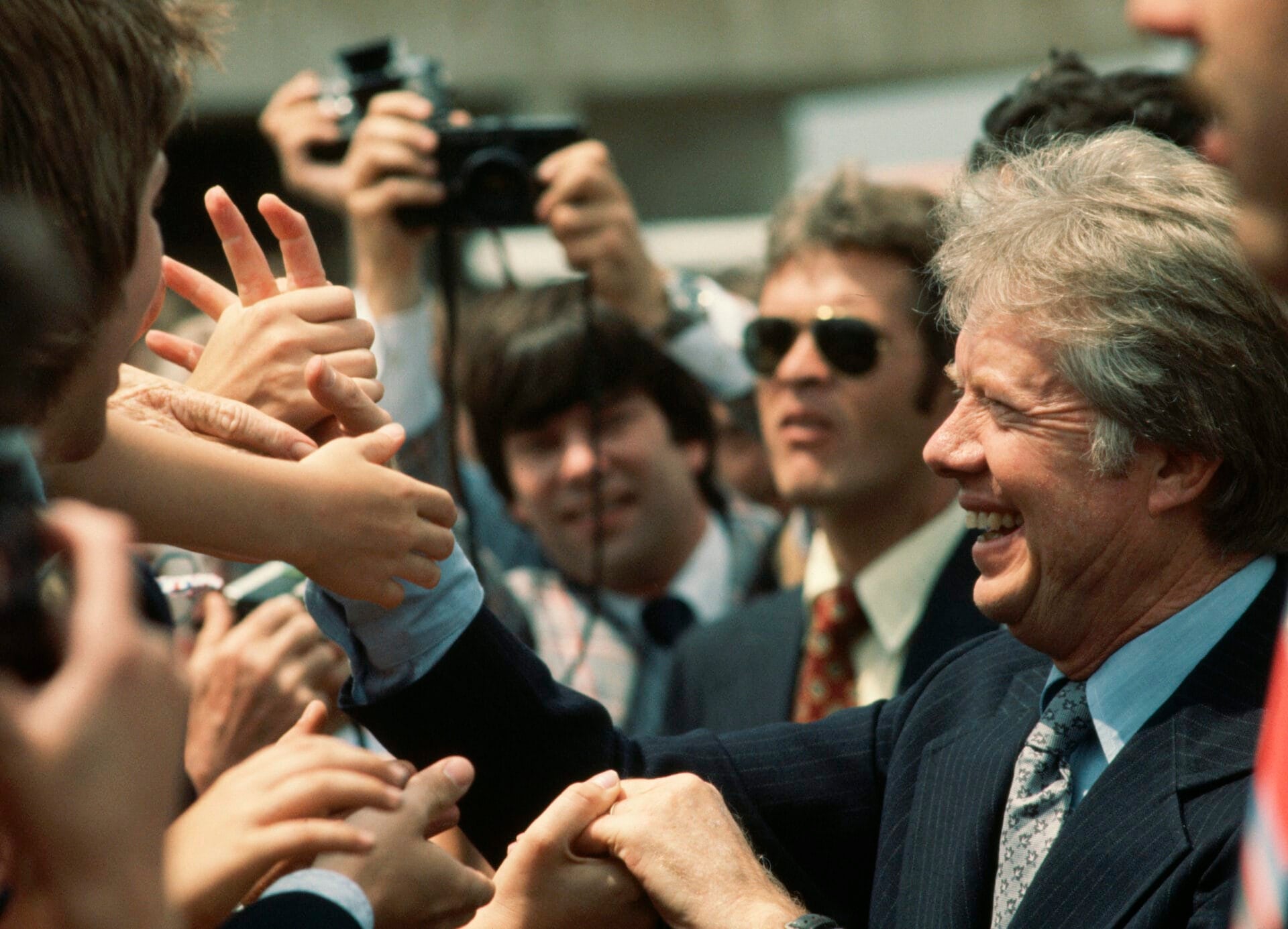 President Jimmy Carter happily shakes hands with a crowd who showed up to meet him at the airport in South Bend, Indiana, on his arrival for 1977 Notre Dame graduation ceremonies. (Photo by Wally McNamee/CORBIS/Corbis via Getty Images)