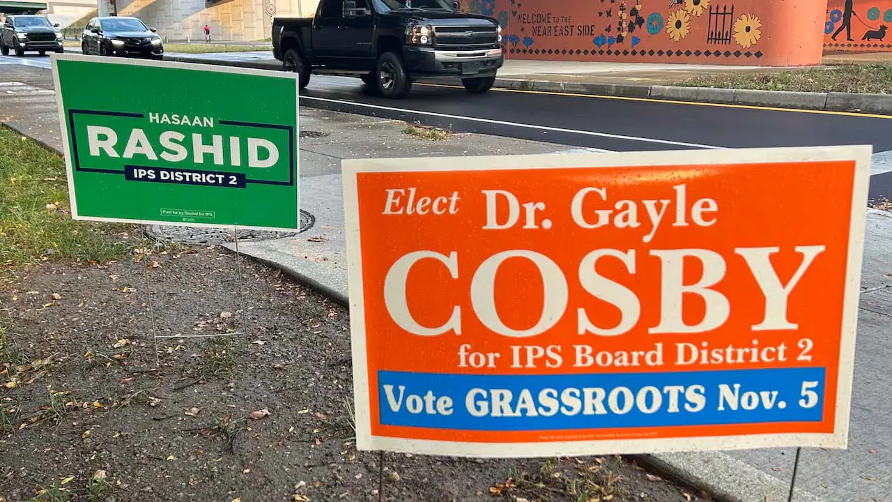 Signs for Gayle Cosby and Hasaan Rashid, candidates for the District 2 seat on the Indianapolis Public Schools board, sit off Tenth Street in Indianapolis. Rashid has raised roughly $43,110, with Cosby at $31,475. (Photo by Amelia Pak-Harvey for Chalkbeat)