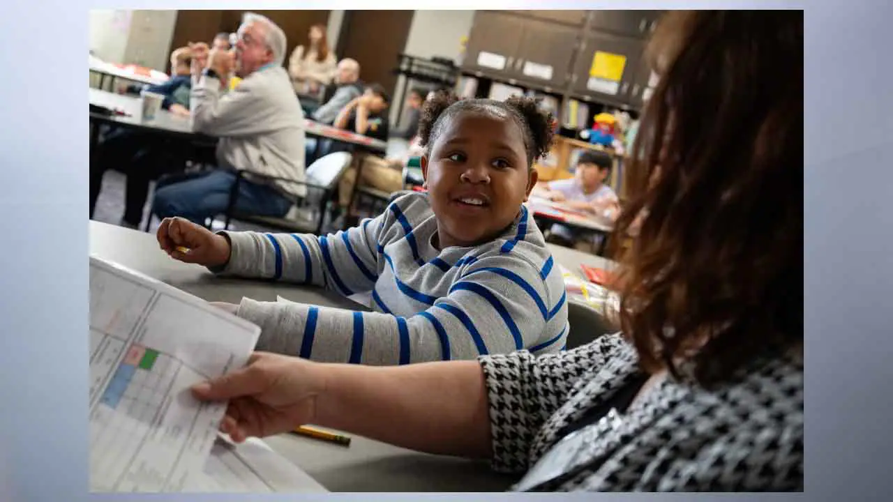 Student Selena Zavala (center) reads with mentor Bonnie Johnson during Wayne Township’s HOSTS program on Nov. 7, 2024, at Stout Field Elementary School in Indianapolis. (Photo by Jennifer Wilson Bibbs for Mirror Indy)