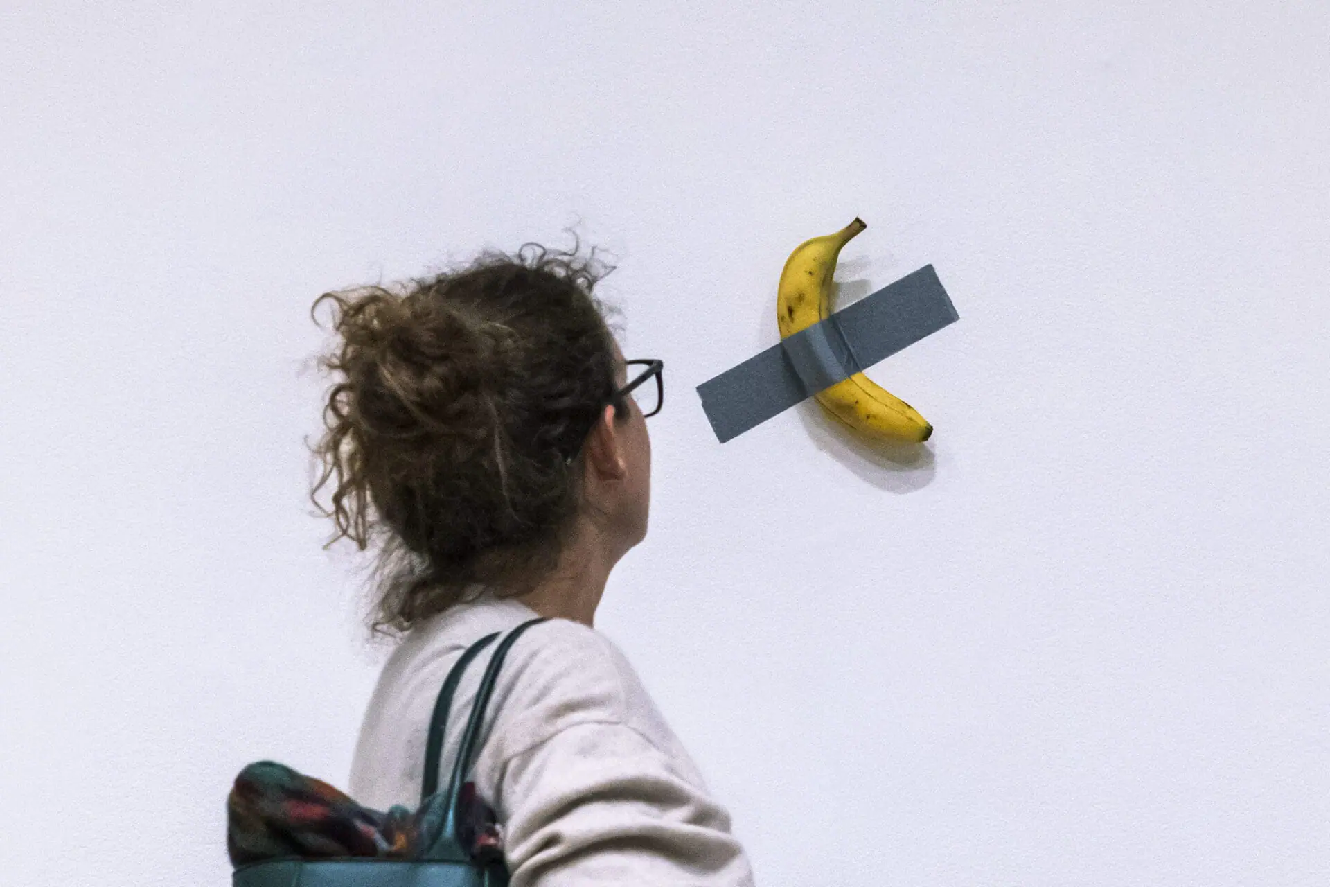 A woman looks at artist Maurizio Cattelan's piece of art 