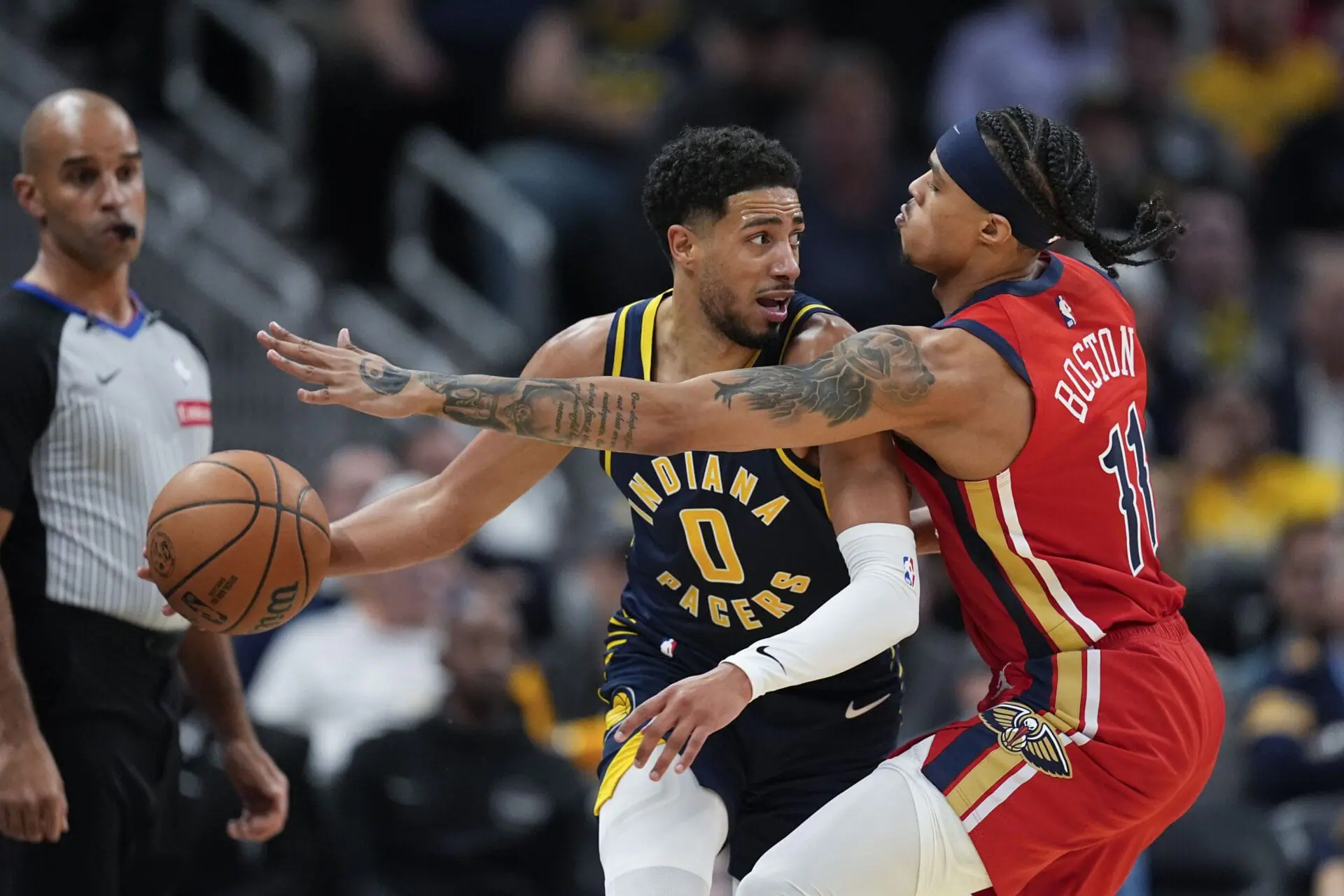 Indiana Pacers' Tyrese Haliburton (0) makes a pass against New Orleans Pelicans' Brandon Boston Jr. (11) during the second half of an NBA basketball game, Monday, Nov. 25, 2024, in Indianapolis. (AP Photo/Darron Cummings)