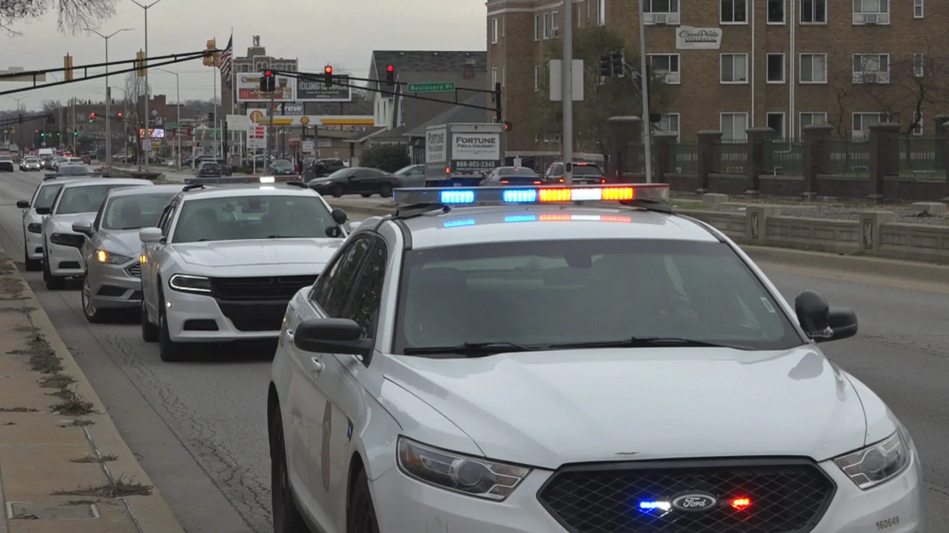 Police cars lined up along West 38th Street following a double shooting on Dec. 3, 2024. (WISH Photo)