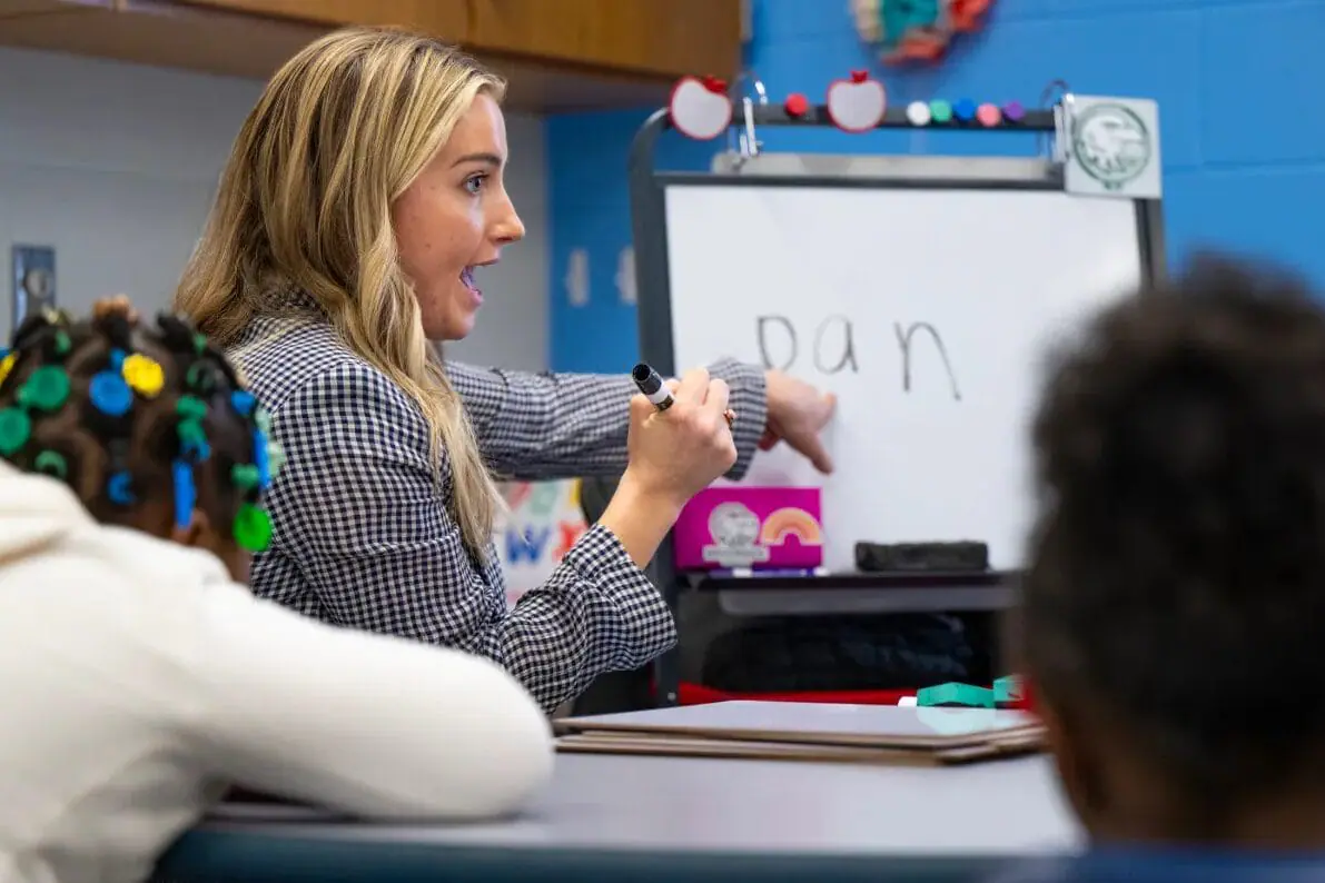 Madelene Rosenberger works with a group of kindergarteners on letter sounds Nov. 25, 2024, at IPS Brookside School 54 in Indianapolis. The Indy Learning Team is a local nonprofit that often works behind the scenes to provide free tutoring and literacy training to schools and community organizations. (Provided Photo/Doug McSchooler for Mirror Indy)