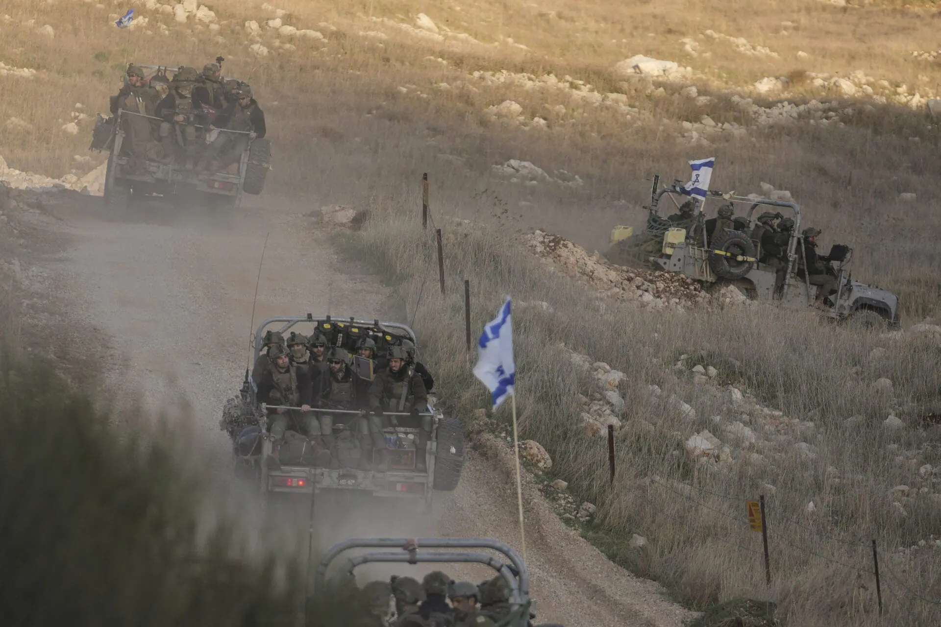 Israeli soldiers cross the security fence moving towards the so-called Alpha Line that separates the Israeli-annexed Golan Heights from Syria, in the town of Majdal Shams, Sunday, Dec. 15, 2024. (AP Photo/Matias Delacroix, File )