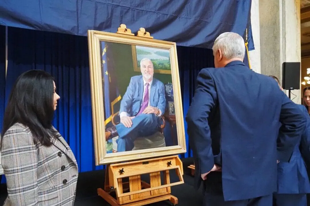 Gov. Eric Holcomb and First Lady Janet Holcomb view the newest gubernatorial portrait, painted by artist Russell Recchion, on Friday, Dec. 13, 2024, following an unveiling ceremony at the Indiana Statehouse. (Photo by Niki Kelly/Indiana Capital Chronicle)