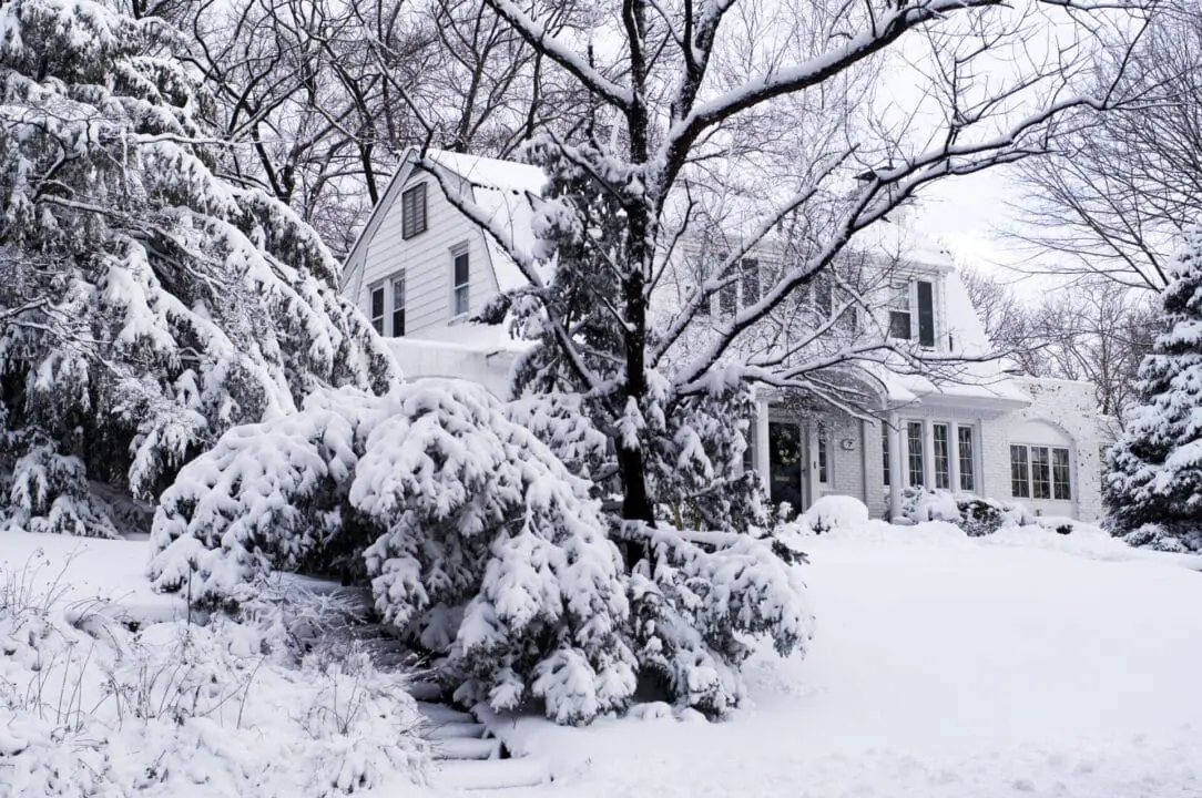 Winter snow covers a residential house. Ice, snow, and wind can cause headaches for homeowners. Thankfully, there are things you can do now to prepare your home before winter weather arrives. (Photo by Rudi Von Briel/Getty Images)