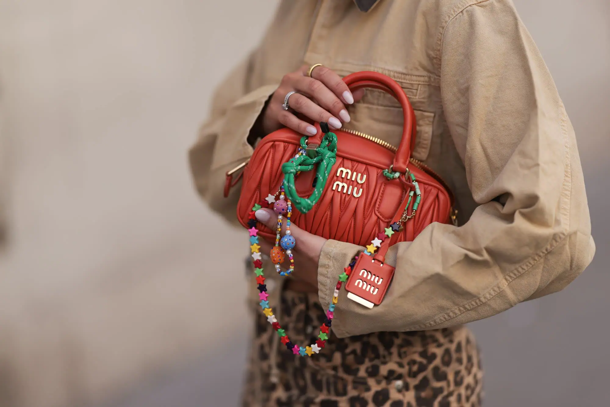 An orange Miu Miu Arcadie bag decked out in charms. (Provided Photo/Jeremy Moeller/Getty Images via CNN Newsource)