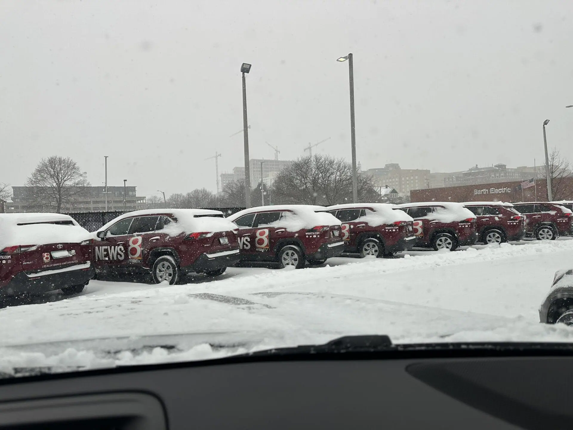 A row of snow-covered news vehicles sit outside the WISH-TV studios on Jan. 6, 2025. (WISH Photo/Hanna Mordoh)