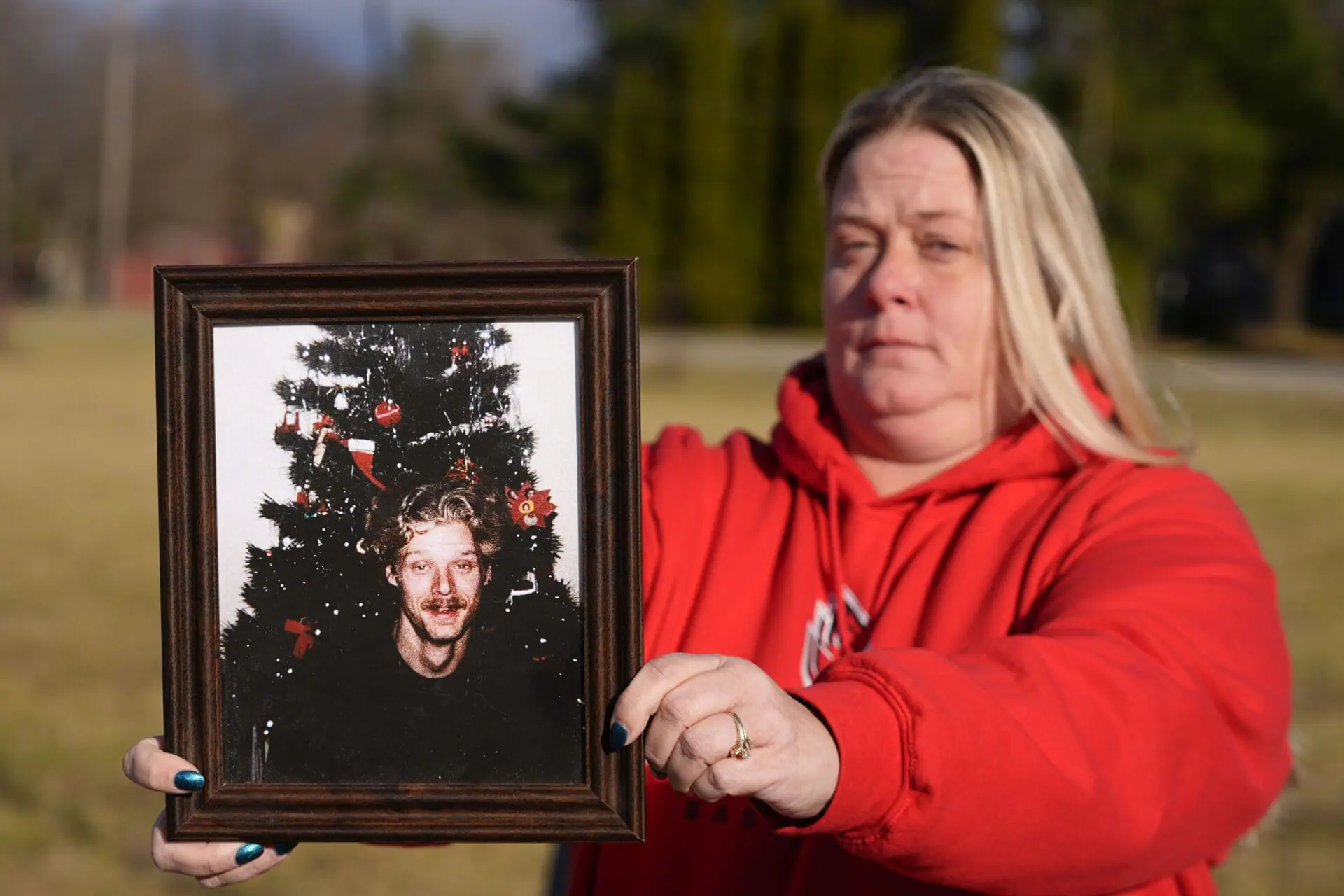 Shannon Doughty holds a photo of her late brother Allen Livingston, who was identified in October 2023 as the ninth known victim of suspected serial killer Herbert Baumeister, Saturday, Dec. 21, 2024, in Westfield, Ind. (AP Photo/Darron Cummings)